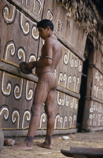 COLOMBIA, North West Amazon, Tukano Indigenous People, Barasana Indian painting design on front of maloca  communal home. Tukano sedentary tribe Indian North Western Amazonia maloca American Colombian Columbia Hispanic Indegent Latin America Latino South America Tukano One individual Solo Lone Solitary
