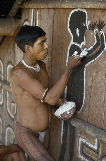 COLOMBIA, North West Amazon, Tukano Indigenous People, Cropped shot of Barasana Indian painting spirit guardian on front of maloca communal home. Tukano sedentary tribe Indian North Western Amazonia maloca American Colombian Columbia Hispanic Indegent Latin America Latino Religion South America Tukano One individual Solo Lone Solitary Religious