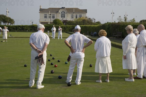 ENGLAND, West Sussex, Bognor Regis, Men and women playing a game of bowls on beach front green