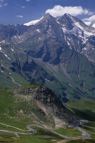 AUSTRIA, Hohe Tauern, Glockner Group  , "View towards Glockner Group and the Grossglockner Road from Edelweisse-spitze view point.  Jagged points with snow lying in crevices of peaks, grassy lower slopes. "