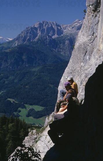 AUSTRIA, Salzburg, Eisriesenwelt, "Group of hikers at cave entrance near Werfen looking out over green, wooded slopes of valley below."