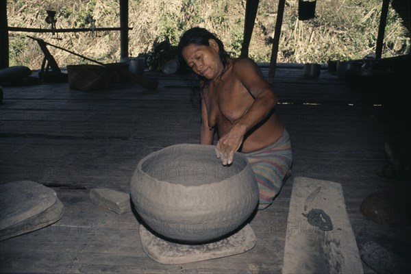 COLOMBIA, Choco, Embera Indigenous People, Old Embera woman coiling a large clay cooking pot. Skill is only continued by a very few elderly women since ceramic pots have been replaced by aluminium. Pacific coastal region tribe vessel American Colombian Colombia Female Woman Girl Lady Female Women Girl Lady Hispanic Indegent Latin America Latino Old Senior Aged South America  Pacific coastal region tribe vessel American Colombian Columbia Female Woman Girl Lady Female Women Girl Lady Hispanic Indegent Latin America Latino Old Senior Aged South America One individual Solo Lone Solitary 1 Aluminum Single unitary