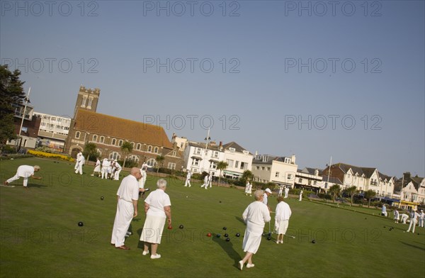 ENGLAND, West Sussex, Bognor Regis, Men and women playing a game of bowls on beach front green. Angled view.
