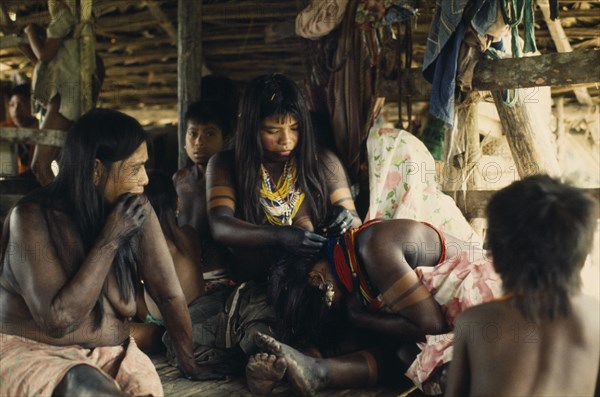 COLOMBIA, Choco, Embera Indigenous People, "Embera family group with young women painted with black dye extracted from Jagua fruit and wearing brightly coloured glass bead necklaces. Tiny glass beads  originating from Europe are coveted trade goods. Family assembled for ""canta hai"" curing ceremony   Pacific coastal region tribe body decoration American Colombian Colored Colombia Female Woman Girl Lady Hispanic Indegent Latin America Latino South America  Pacific coastal region tribe body decoration American Colombian Colored Columbia Female Woman Girl Lady Hispanic Indegent Latin America Latino South America Female Women Girl Lady Immature European Young Unripe Unripened Green "