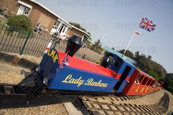 ENGLAND, West Sussex, Littlehampton, Families enjoying the Miniature Railway train ride at Norfolk Gardens. Union Jack Flag flying behind
