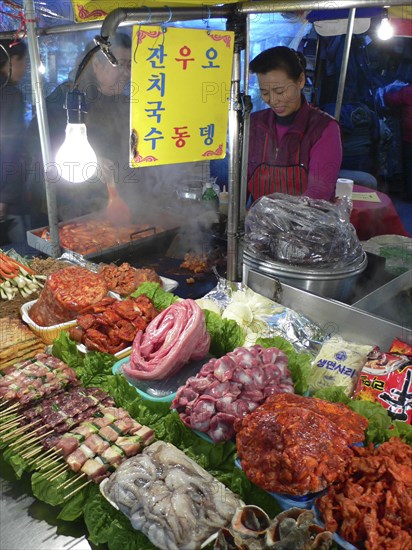 KOREA, South, Seoul, "Namdaemun - Namdaemun Market, December evening, food stall with chicken, meat, and fish waiting to be cooked"