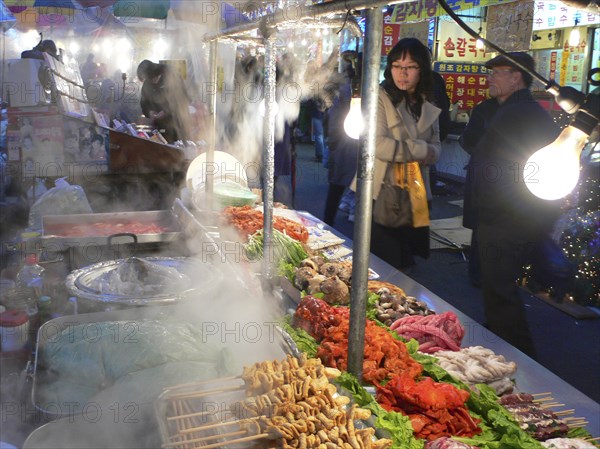 KOREA, South, Seoul, "Namdaemun - Namdademun market, December evening, steam rising from food stalls, meat and fish, people walking by"