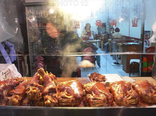 KOREA, South, Seoul, "Namdaemun - Namdaemun market, outside a roast pork restaurant, woman cutting pork"