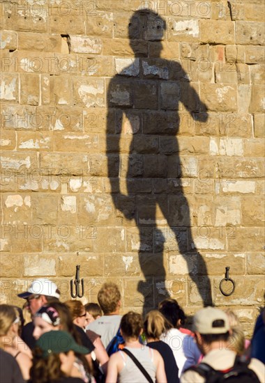 ITALY, Tuscany, Florence, Tourists outside the Palazzo Vecchio in the Piazza della Signoria beneath the shadow of the statue of David by Michelangelo