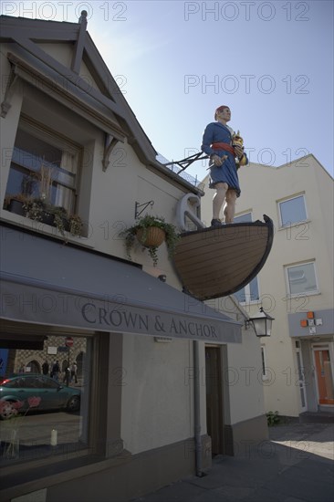 ENGLAND, West Sussex, Shoreham-by-Sea, Exterior of the Crown and Anchor public house in the high street with ships mast head figure in the fonrt of the building.