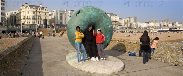 ENGLAND, East Sussex, Brighton, Tourists posing for photographs next to sculture on the seafront.