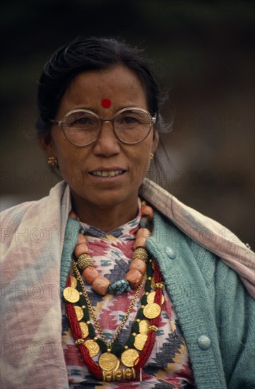 NEPAL, Annapurna Region, Larjung, Circuit Trek. Portrait of Thakali woman wearing traditional dress and jewellery with a Bindi red spot decoration on forehead during the Lha Phewa festival