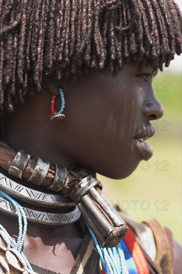 ETHIOPIA, Lower Omo Valley, Key Afir, "Weekly market, Banner woman wearing a necklace know as a Bignere - an metal band with a phallic protuberance to signify that she is a first wife"