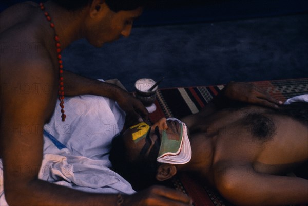 20086566 INDIA Kerala Dance Kathakali dancers applying make-up before performance.