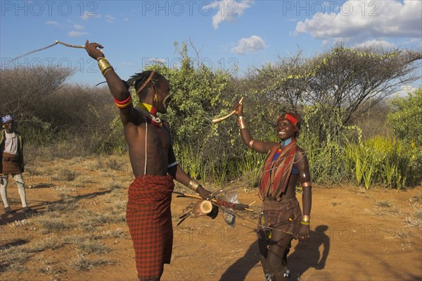 ETHIOPIA, Lower Omo Valley, Tumi, "Hama Jumping of the Bulls initiation ceremony. Man whipping women on back in ritual flogging