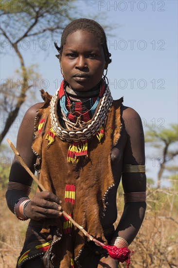 ETHIOPIA, Lower Omo Valley, Tumi, "Dombo village, Hamer lady holding spoon she has used to stir cows bood ready for drinking"