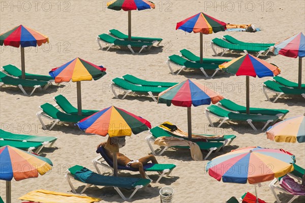 SPAIN, Balaeric Islands, Ibiza, Eivissa. Parasols and sunbeds on the beach.