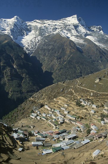 NEPAL, Everest Trek, Namche Bazaar, Elevated view over village rooftops of Namche Bazaar with Kwangde Himal mountain in the background