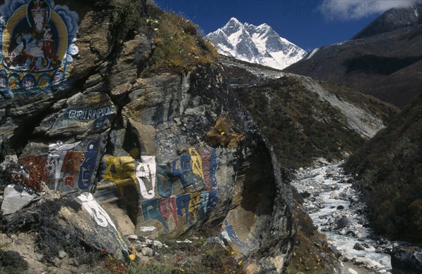 NEPAL, Everest Trek, Pangboche, Buddhist wall paintings beside the trail between Pangboche and Shomare with snow capped Lhotse mountain in the backgound