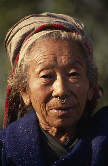 NEPAL, East, Palati, Head and shoulders portrait of elderly woman wearing a nose ring in Palati Village near the Arun River valley