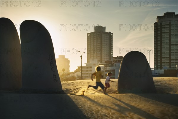 20091073 La Mano Sculpture hand beach Praya Brava  with children playing evening light. American Beaches Hispanic Immature Kids Latin America Latino Resort Sand Sandy Seaside Shore South America Tourism Warm Light  Region - South AmericaBeach - EmptyDom