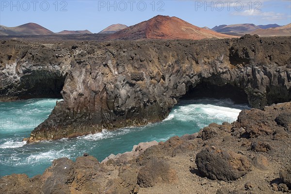SPAIN, Canary Islands, Lanzarote, "Los Hervideros or Boiling Waters from viewpoint on south west coast road. The sea crashes through lava formed tunnels, sea eroded chimneys and arches as if boiling."