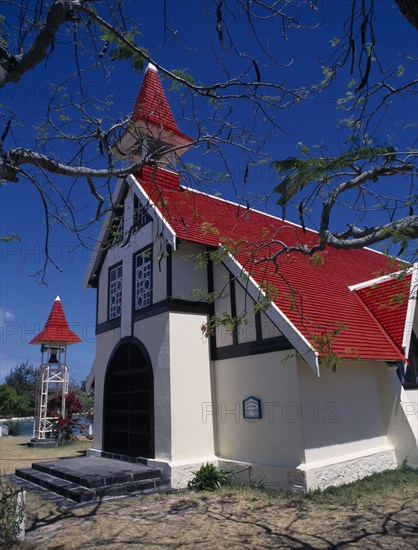MAURITIUS, North, Poudre d’Or, "Marie-Reine Church.  White painted exterior with red tiled roof and free standing bell tower, part framed by tree branches."