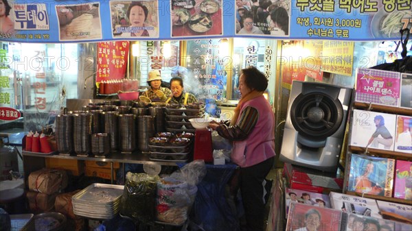 KOREA, South, Seoul, "Namdaemun market, street restaurant, women getting ready for the evening's customers behind stack of dishes"