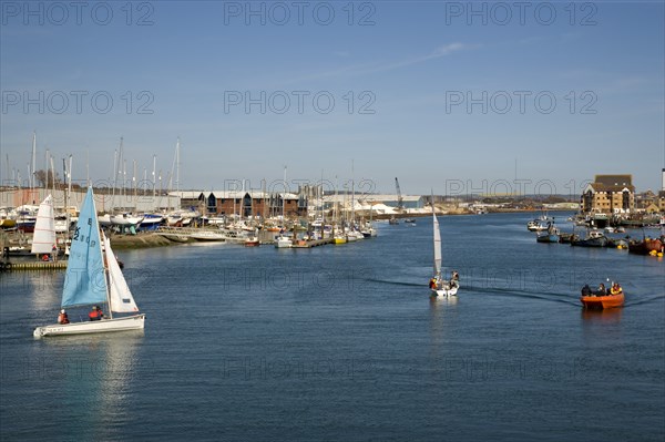 ENGLAND, West Sussex, Shoreham-by-Sea, People sailing their dingies in the river Adur next to the marina.
