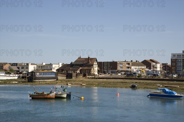 ENGLAND, West Sussex, Shoreham-by-Sea, View across the river Adur from the footbridge toward the Waterside Inn pub on Shoreham Beach.