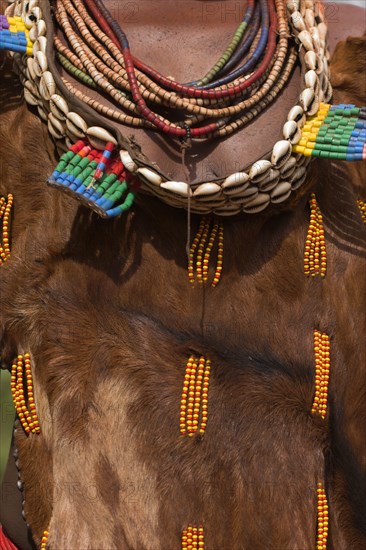 ETHIOPIA, Omo Valley, Mago National Park, Womans necklaces and traditional goatskin dress decorated with cowrie shells