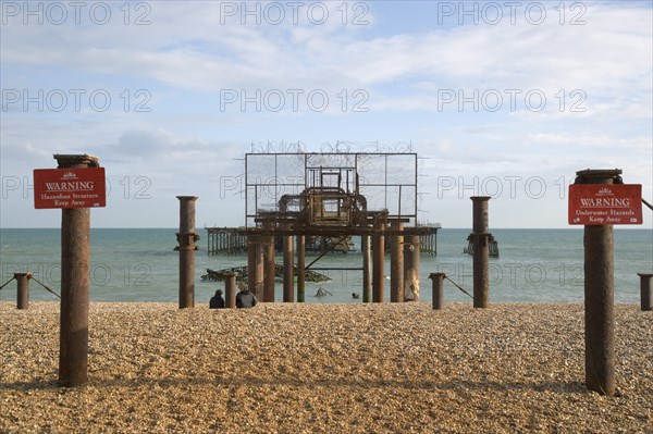 ENGLAND, East Sussex, Brighton, Ruins of the West Pier with warning signs.