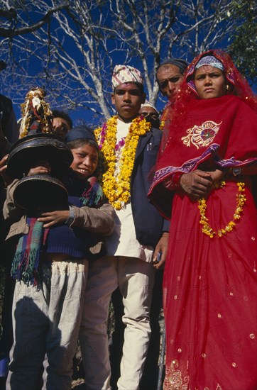 NEPAL, East,  Sangawa Khola, Bride and groom during wedding procession. Groom wearing a marigold garland and bride dressed in red.