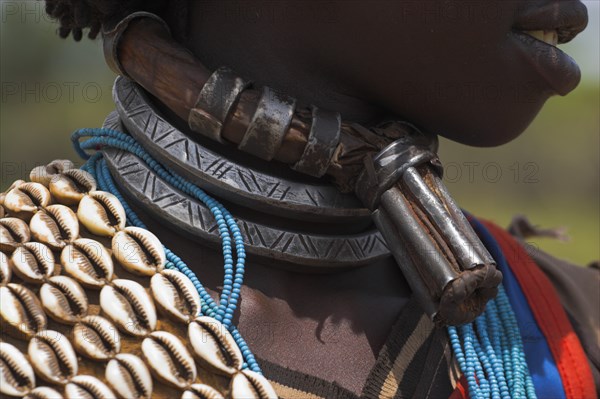 ETHIOPIA, Lower Omo Valley, Key Afir, Banner woman wearing a necklace know as a Bignere - an metal band with a phallic protuberance to signify that she is a first wif