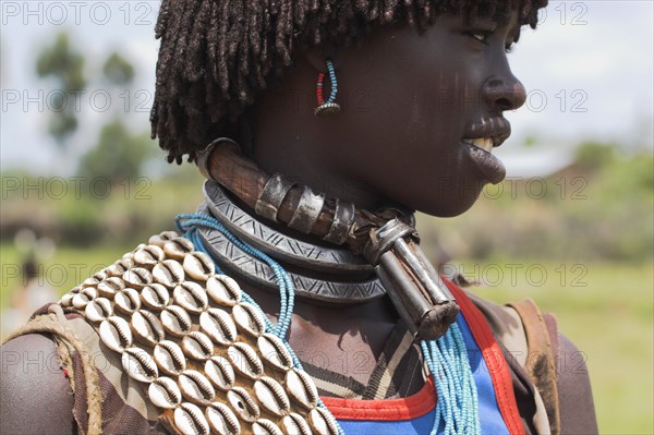 ETHIOPIA, Lower Omo Valley, Key Afir, Banner woman wearing a necklace know as a Bignere - an metal band with a phallic protuberance to signify that she is a first wife