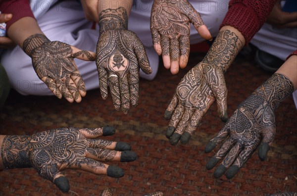 INDIA, Rajasthan, Nawalgarh, Detail of a group of hands with various henna designs in the Mehndi competition at the Shekhawati Festival