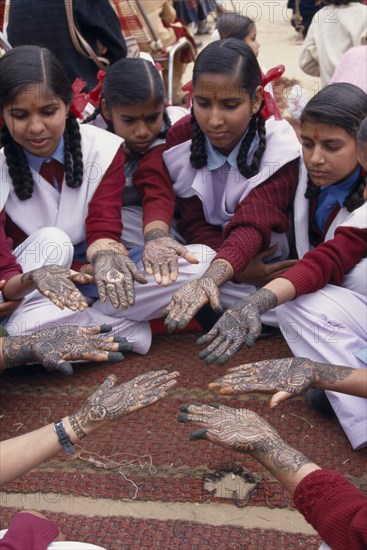 INDIA, Rajasthan, Nawalgarh, Schoolgirls displaying henna designs on their hands in the Mehndi competition at the Shekhawati Festival