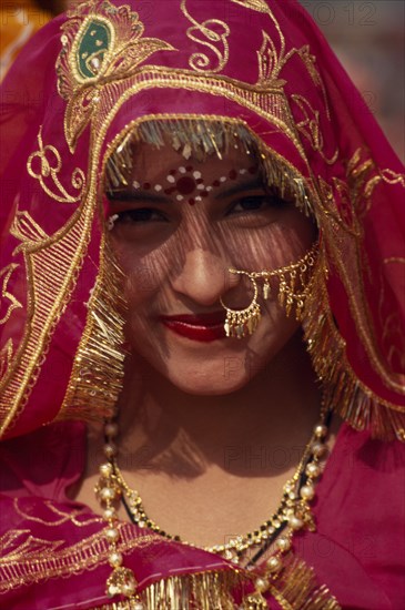 INDIA, Rajasthan, Jhunjhunu, Head and shoulders portrait of a female dancer in traditional dress before the start of the Shekhawati Festival