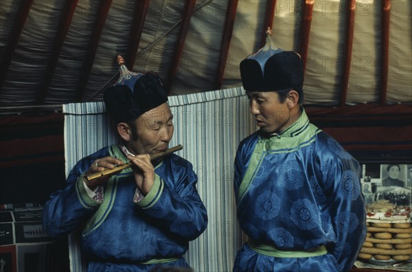 MONGOLIA, Gobi Desert, Biger Negdel, Flute player and chanter in fine traditional silk tunics during celebrations for the Mongolian Lunar New Year or Tsagaan Tsaar.  East Asia Asian Classic Classical Historical Mongol Uls Older