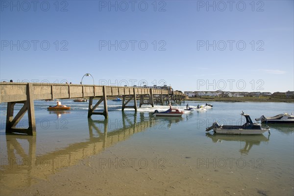 ENGLAND, West Sussex, Shoreham-by-Sea, Footbridge across the river Adur with waterskiers passing under.