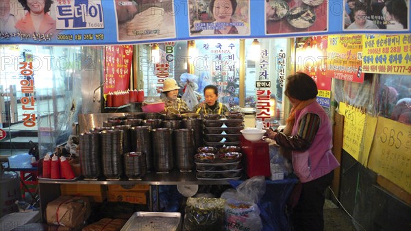 KOREA, South, Seoul, "Namdaemun market, street restaurant, women get ready for evening's customers behind stacks of dishes"