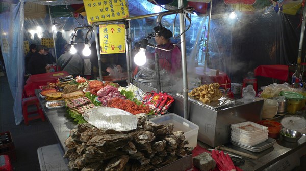 KOREA, South, Seoul, "Namdaemun market, street restaurant, stacks of meat and fish waiting to be dooked, oysters in foreground"