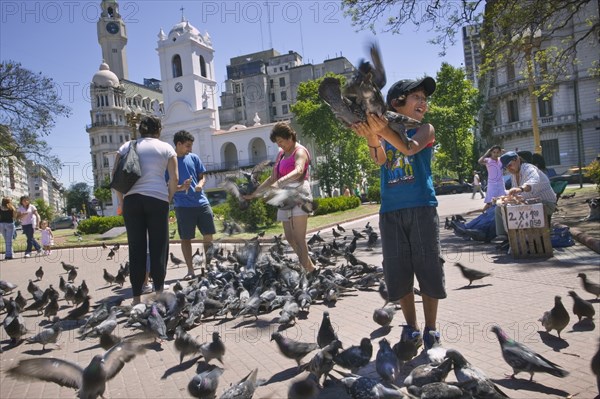 ARGENTINA, Buenos Aires, Feeding the pigeons in Plaza de Mayo.