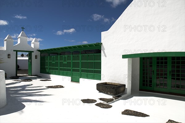 SPAIN, Canary Islands, Lanzarote, La Casa Museo a La Campesino or the Farmhouse Museum. Green painted entrance gate and wall of complex from inside looking outwards.