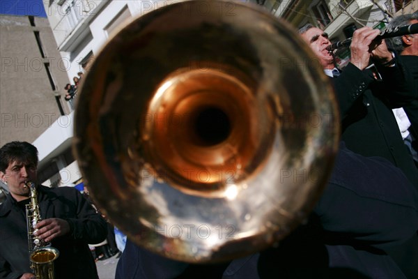 GREECE, Macedonia, Kozani, Greek street musicians playing their instruments at the celebration of the traditional Kozani carnival called Fanoi.  Trumpet player in imediate foreground.
