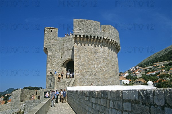 CROATIA, Dalmatian Coast, Dubrovnik, View along old city walls to Minceta Fort Tower and tourists. Former Yugoslavia
