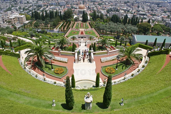 ISRAEL, Northern Coast, Haifa, "Zionism Avenue.  View of Baha'i Shrine and Gardens built as memorial to founders of the Bah’ai faith.  Formal layout of flowerbeds and pathways with cypress trees, central domed shrine and city beyond."