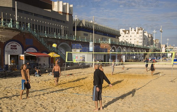 ENGLAND, East Sussex, Brighton, People playin beach volleyball on the seafront outside the Grand Hotel.