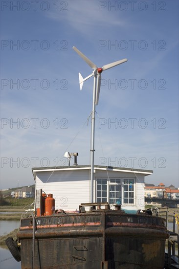 ENGLAND, West Sussex, Shoreham-by-Sea, "Houseboat, with large wind turbine in the deck, moored along the banks of the river adur. Wind turbine to generate electricity for the vessel."
