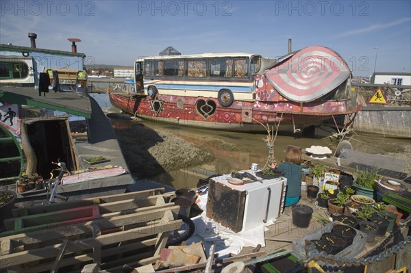 ENGLAND, West Sussex, Shoreham-by-Sea, "Houseboat moored along the banks of the river adur.  Former barges converted into homes with the use of various bits of junk, including cars, buses and washing machines."